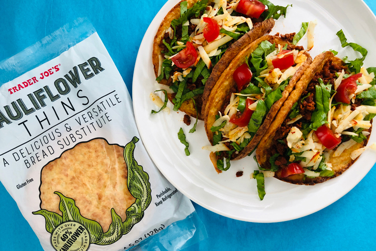 plate of soy chorizo tacos next to a package of Trader Joe's Cauliflower Thins